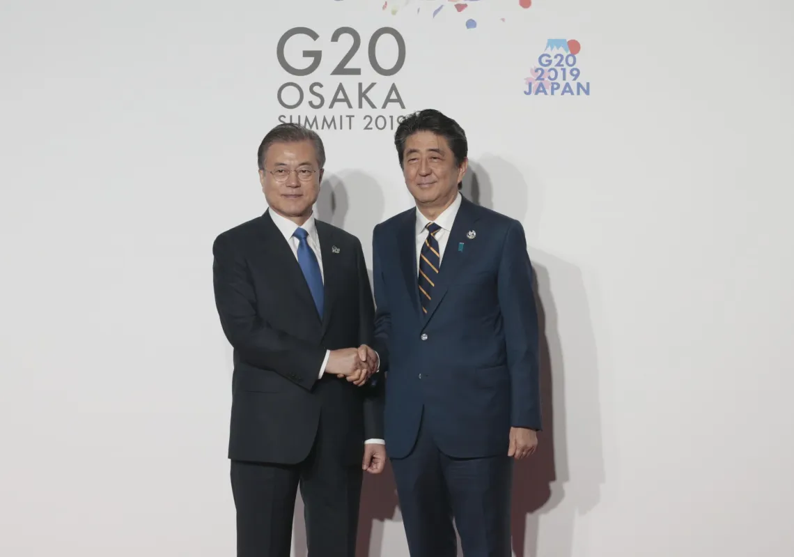 President of South Korea Moon Jae-in (L) is welcomed by Japanese Prime Minister Shinzo Abe (R) on the first day of the G20 summit in Osaka, Japan on June 28, 2019. (Getty)