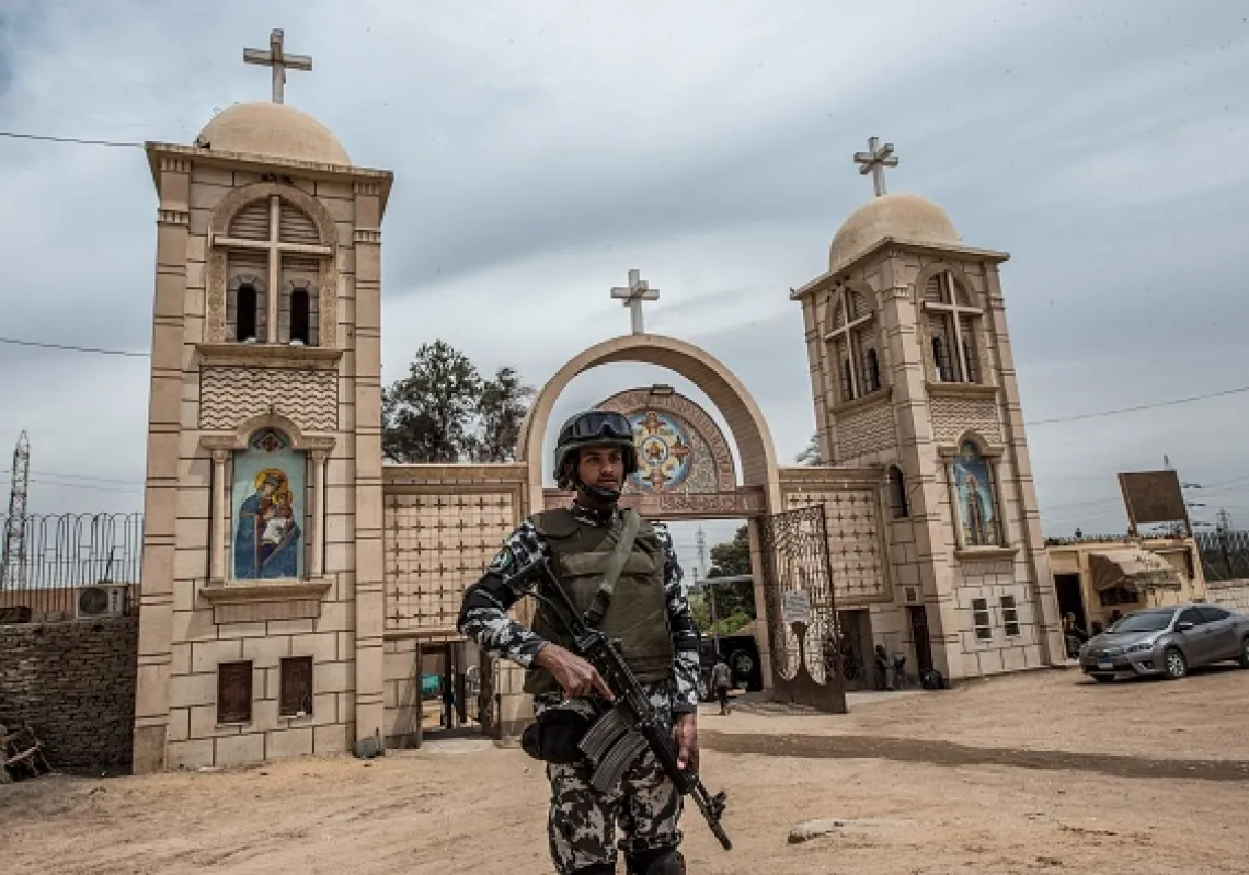 أحد أفراد قوات الأمن المصرية في حراسة بوابة «الدير الأبيض» في محافظة سوهاج جنوبي مصر (غيتي)