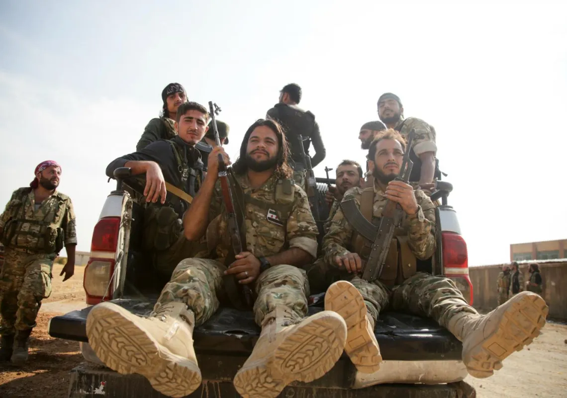 مقاتلون سوريون مدعومون من تركيا بين بلدتي تل أبيض وكوباني، شمالي سوريا (أ.ف.ب)