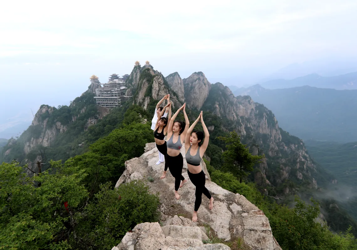 People practice yoga on a cliff at an attitude of over 2,000 meters at Laojunshan mountain to welcome upcoming International Yoga Day on June 20, 2020 in Luoyang, Henan Province of China. (Getty)