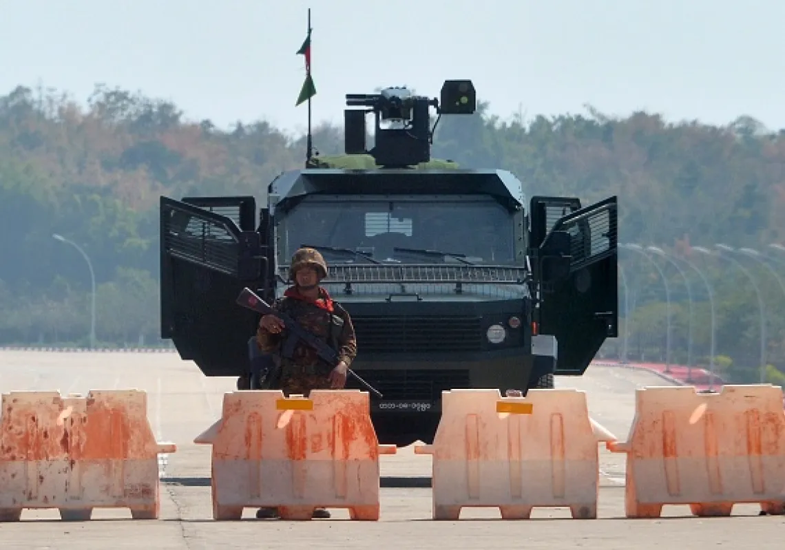 A soldier stands guard on a blockaded road to Myanmar's parliament in Naypyidaw on February 1, 2021, after the military detained the country's de facto leader Aung San Suu Kyi and the country's president in a coup. (Getty)