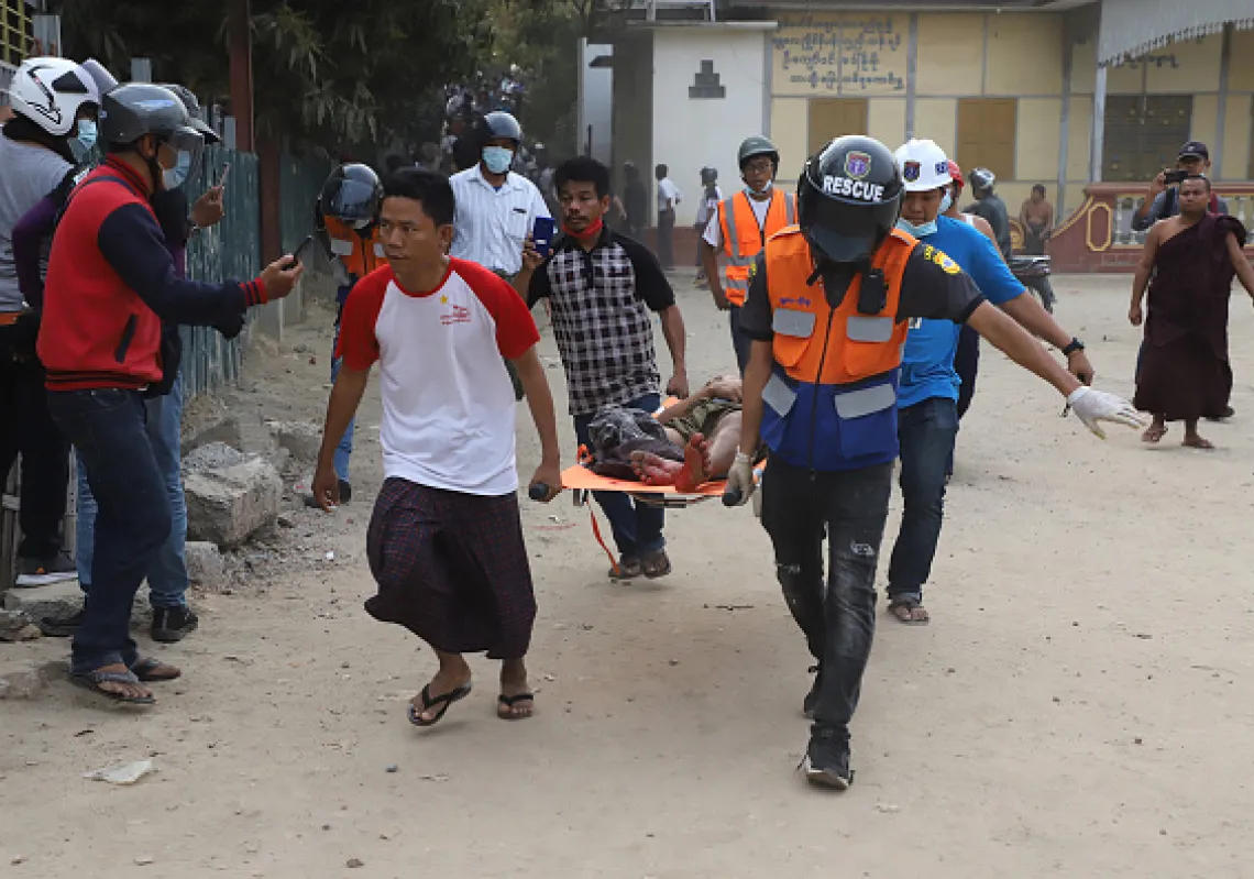 A wounded man is carried on a stretcher by a medical team after security forces opened fire on protesters during a demonstration against the military coup in Mandalay on February 20, 2021.(Getty)