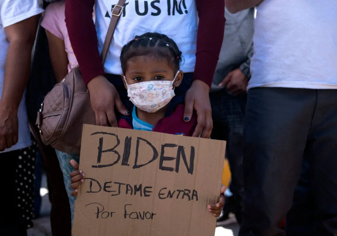 Dareli Matamoros, a girl from Honduras, holds a sign asking President Biden to let her in during a migrant demonstration demanding clearer United States migration policies, at San Ysidro crossing port in Tijuana, Baja California state, Mexico on March 2, 2021. (Getty)