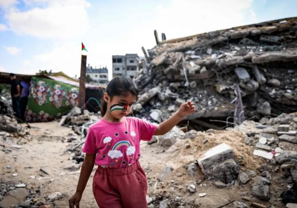  A Palestinian girl with a national flag painted on her face, plays amidst the rubble of buildings destroyed by last month's Israeli bombardment of the Gaza Strip, in Beit Lahia, in the northern part of the Palestinian enclave, on June 19, 2021. (AFP)