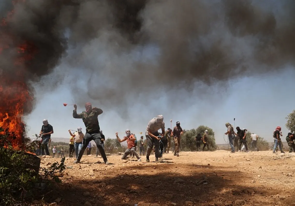  Palestinian protesters use slingshots to throw stones during clashes with Israeli security forces in the town of Beita, near the occupied West Bank city of Nablus, on July 2, 2021.(Getty)