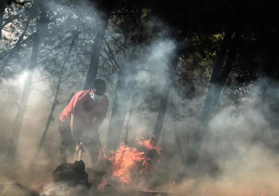 A local resident tries to contains fire in Thrakomakedones, near Mount Parnitha, north of Athens, on August 7, 2021. - Hundreds of firefighters battled a blaze on the outskirts of Athens as several fires raged in Greece. (Photo by Louisa GOULIAMAKI / AFP)