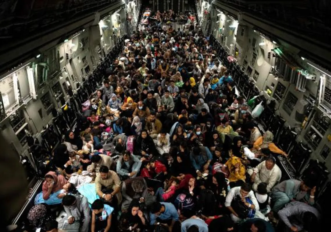 In this image courtesy of the US Central Command Public Affairs, Afghans civilians are evacuated by the US military on August 19, 2021, at an undisclosed location. - A Pentagon official confirmed Friday that US evacuation operations from Kabul's airport have been stalling because the receiving base in Qatar is overflowing and could not receive evacuees. "There has been a considerable amount of time today… where there haven't been departures," Brigadier General Dan DeVoe of the US Air Mobility Command told reporters. (Photo by Brandon CRIBELAR / US Central Command Public Affairs / AFP) 