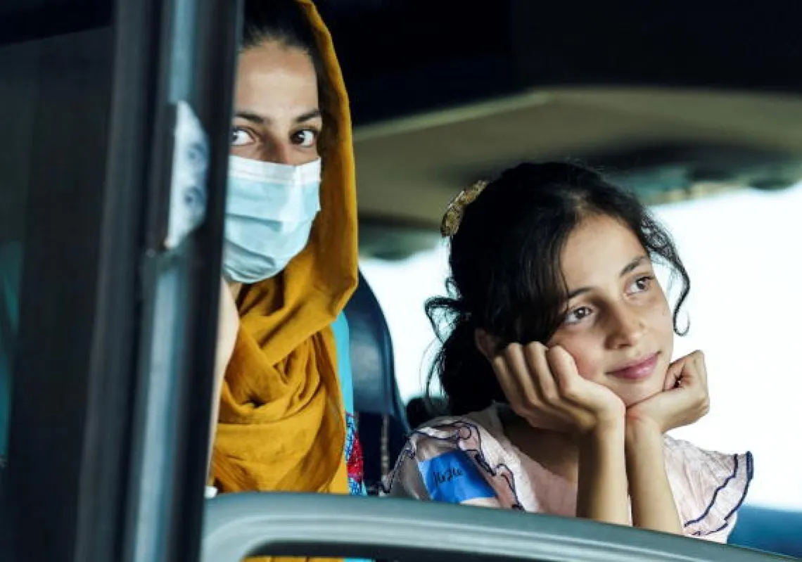 Afghan refugees ride aboard a bus taking them to a refugee processing center upon arrival at Dulles International Airport in Dulles, Virginia August 25, 2021. REUTERS/Kevin Lamarque