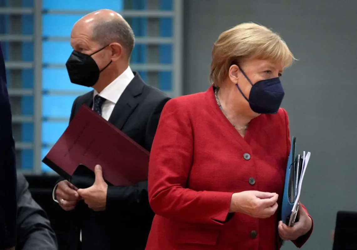 1-	German Chancellor Angela Merkel (R) and German Finance Minister and Vice-Chancellor Olaf Scholz. (Photo by Michale Sohn/AFP)