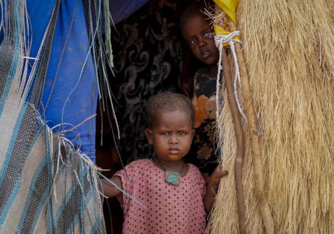 The daughter of a herder family stands in the doorway of their hut near Kuruti, in Garissa County, Kenya Wednesday, Oct. 27, 2021. As world leaders address a global climate summit in Britain, drought has descended yet again in northern Kenya, the latest in a series of climate shocks rippling through the Horn of Africa. (AP Photo/Brian Inganga)