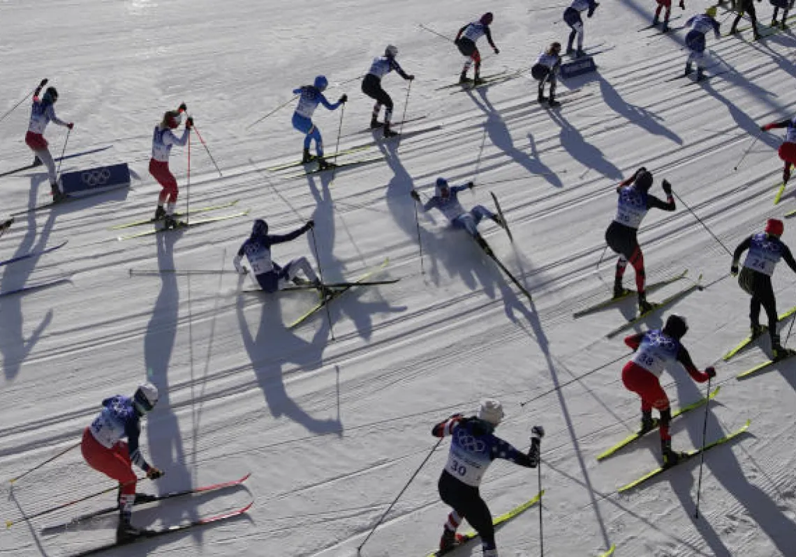 Skiers fall while competing during the women's 7.5km + 7.5km skiathlon cross-country skiing competition at the 2022 Winter Olympics, Saturday, Feb. 5, 2022, in Zhangjiakou, China. (AP Photo/John Locher)