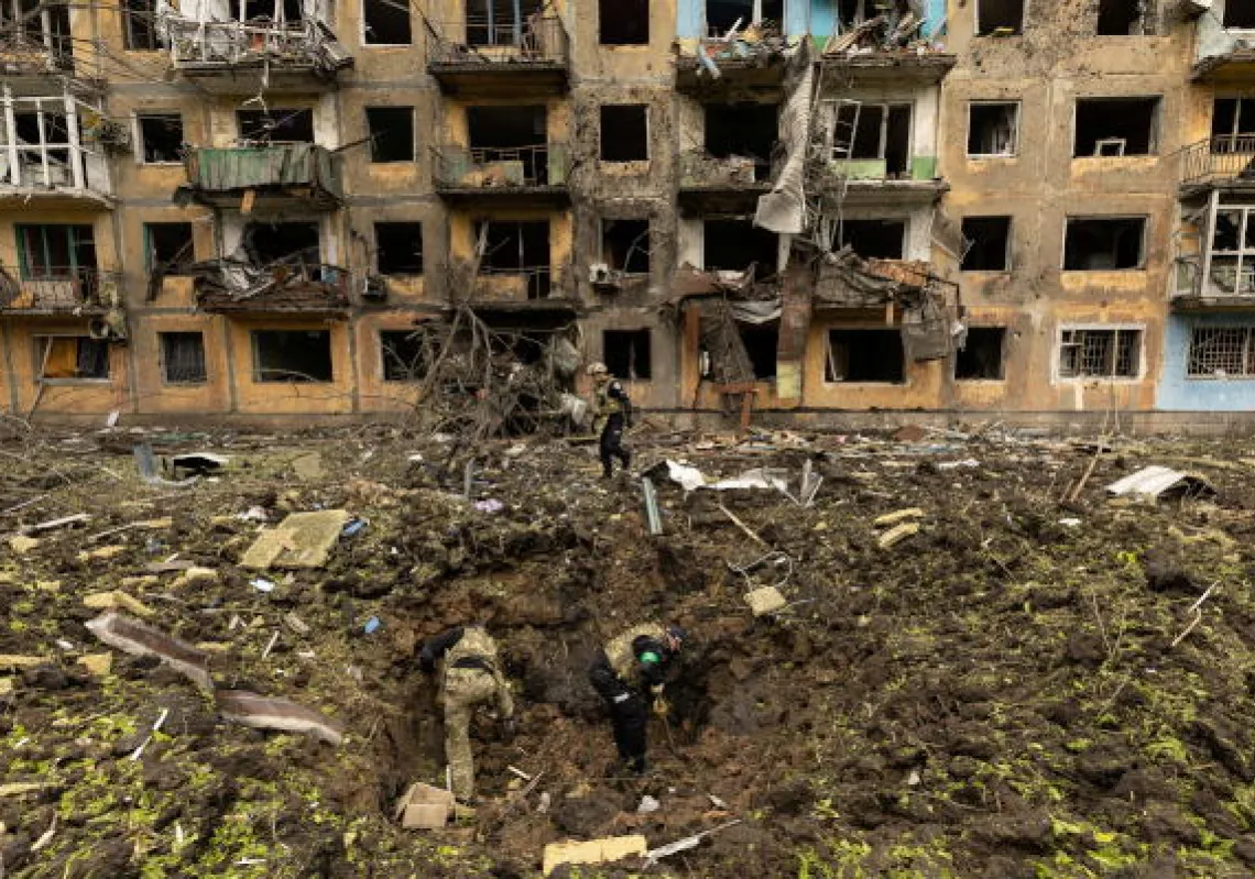 Ukrainian military personnel inspect the site of a missile strike in front of a damaged residential building, amid Russia's invasion, in Dobropillia, in the Donetsk region, Ukraine, April 30, 2022. REUTERS/Jorge Silva