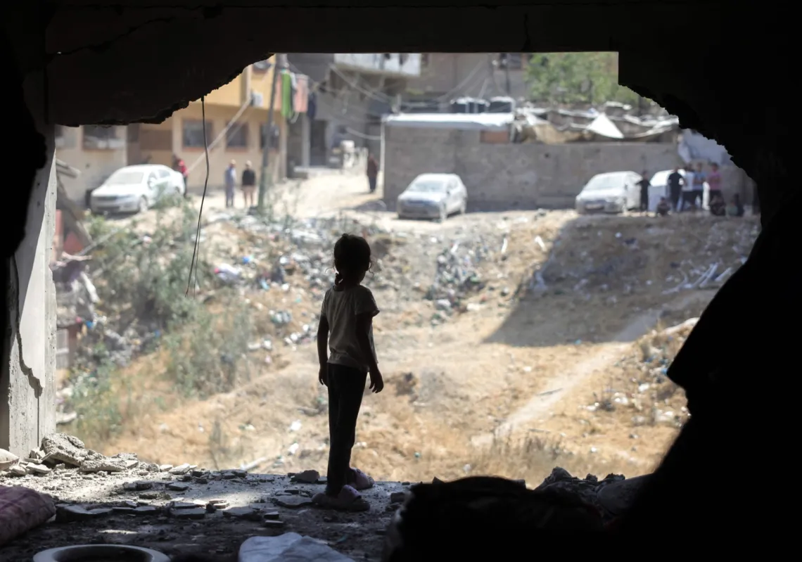 فتاة فلسطينية تنظر في منزل متضرر، في حي الصفطاوي، غرب جباليا، شمال قطاع غزة، بعد استهدافه في غارة إسرائيلية يوم 9 يونيو
