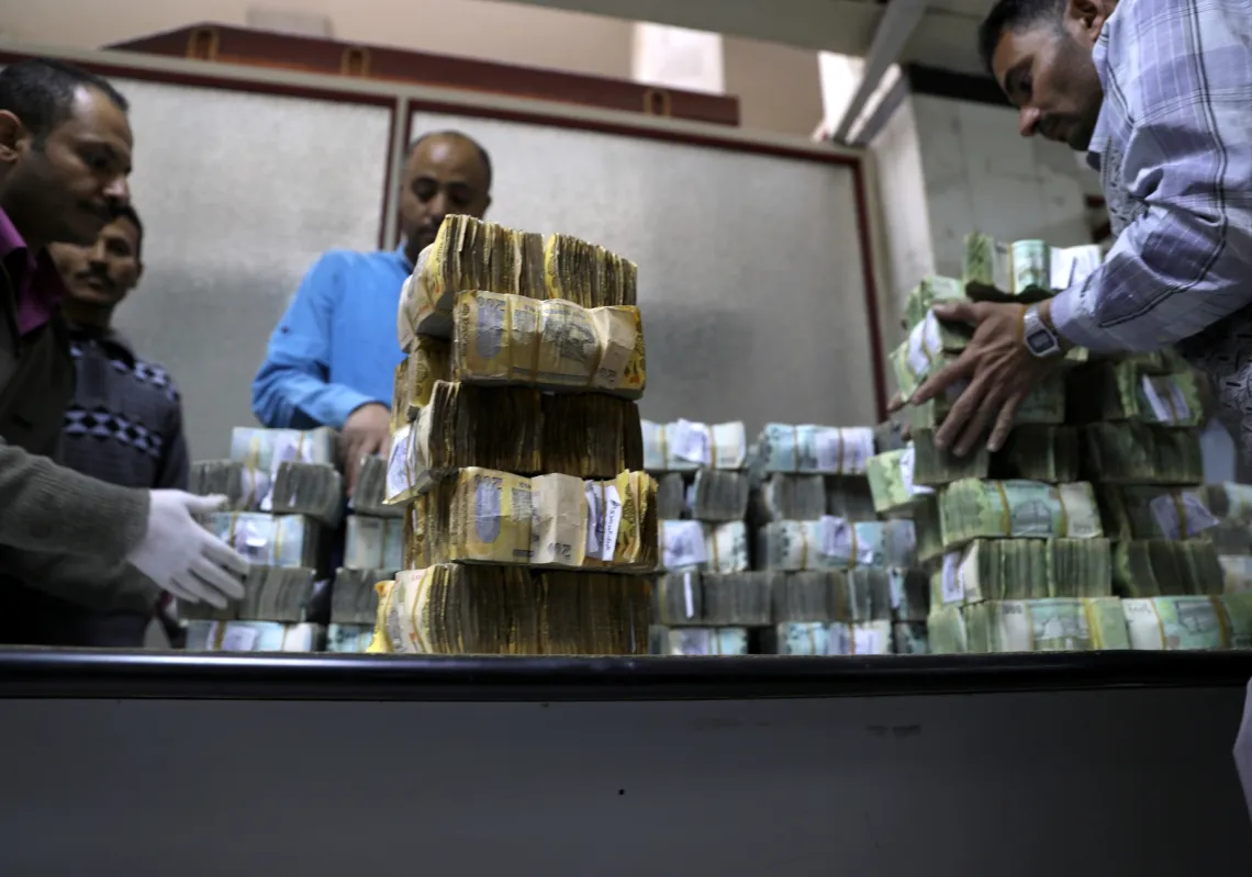 Employees count bundles of Yemeni Riyal banknotes at the Central Bank of Yemen in Sanaa on January 7, 2020.