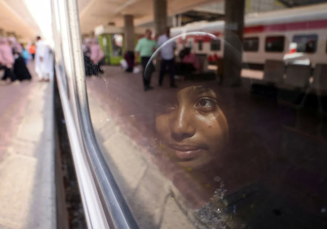 A child looks outside from a train window as Sudanese families displaced by conflict return home voluntarily from Egypt to Sudan, on a special train, Cairo July 21, 2025.