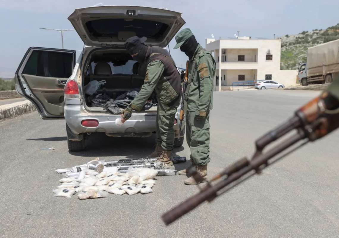 مقاتلون تابعون لـ&quot;هيئة تحرير الشام&quot; السورية يعرضون مخدراتٍ ضبطت سابقا عند نقطة تفتيش يسيطرون عليها في دارة عزة، بريف حلب الشمالي الغربي، في 10 أبريل 2022