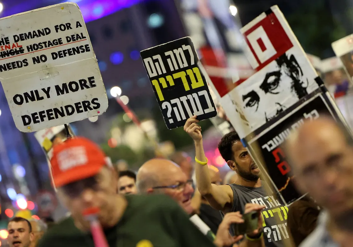 Demonstrators raise placards during an anti-government rally calling for action to secure the release of Israeli captives in Gaza near the defence ministry in Tel Aviv on August 12, 2025.