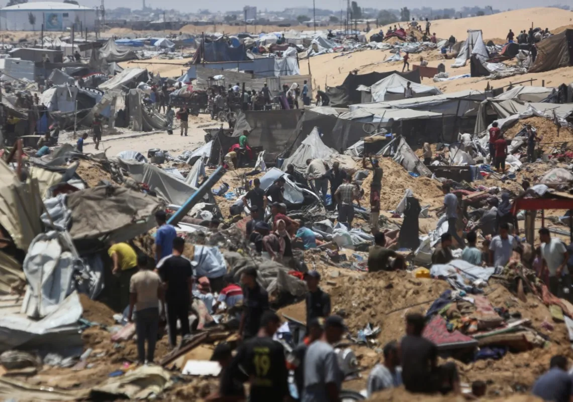 فلسطينيون يتفقدون الدمار في مخيم نازحين مؤقت بعدما اقتحمته دبابات إسرائيلية في اليوم السابق في خان يونس في شمال قطاع غزة في 11 يوليو 2025