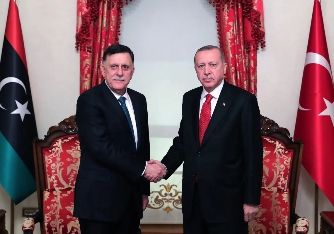 Turkish President Recep Tayyip Erdogan shakes hands with Fayez al-Sarraj, the head of the Tripoli-based Government of National Accord, in Istanbul after signing a military deal on November 27, 2019.