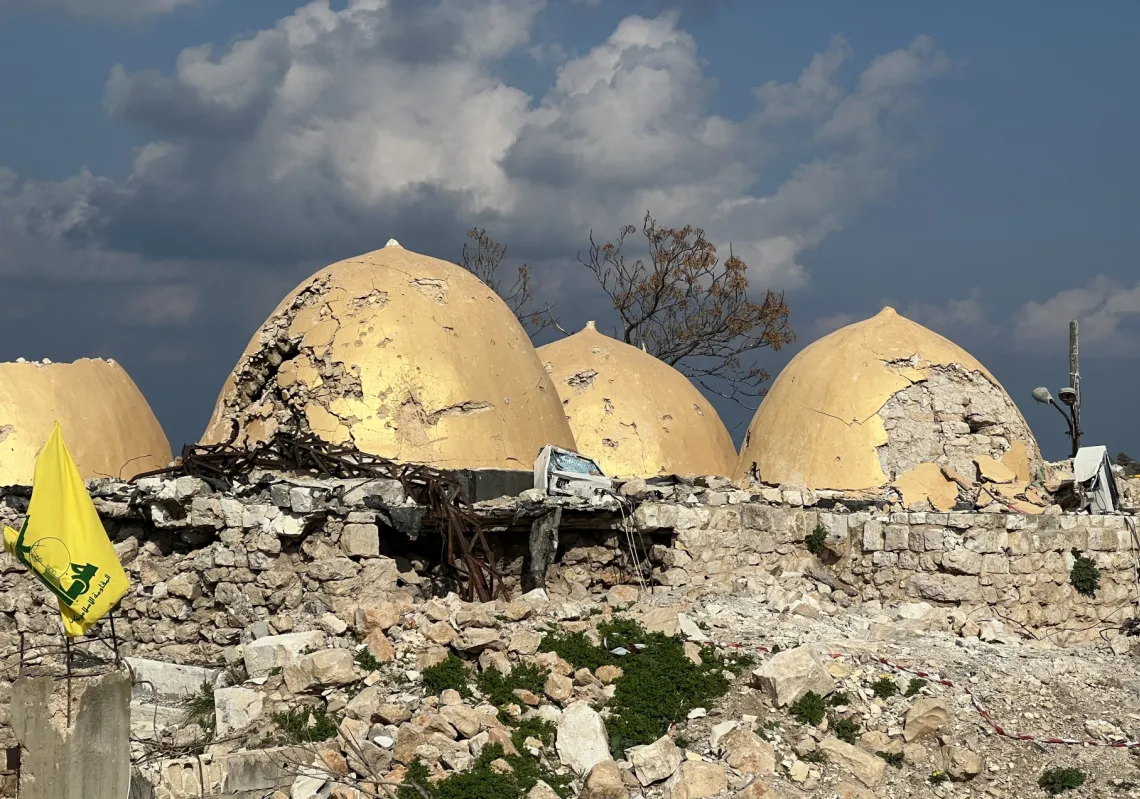 A Hezbollah flag is placed in front of the shrine of Shamoun al-Safa, built within a castle in the village of Shamaa in southern Lebanon's Tyre governorate, on January 31, 2025, that was heavily damaged by Israeli bombing.