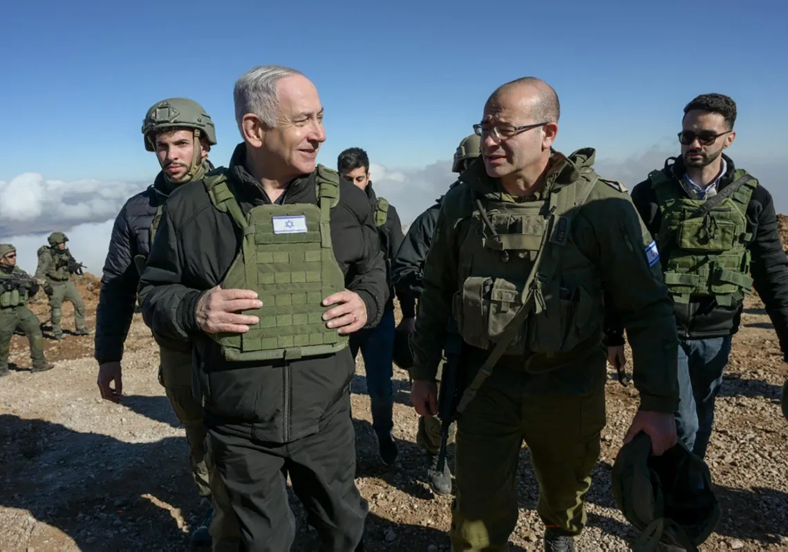 Israeli Prime Minister Benjamin Netanyahu (L) walks among members of the Israeli army at Mount Hermon in the Israeli-annexed Golan Heights of Syria, on December 17, 2024.