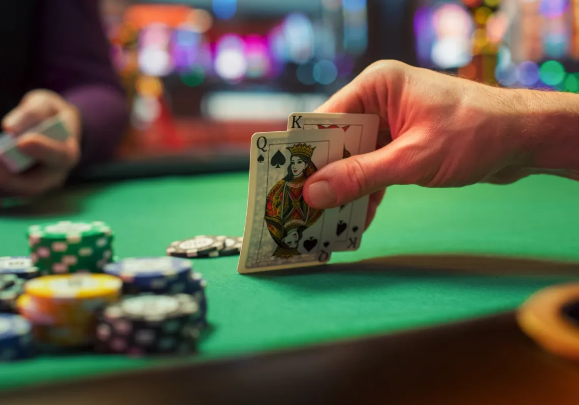 لقطة مقرّبة ليد لاعب بوكر مجهول يتفحص أوراقه خلال بطولة تنافسية
