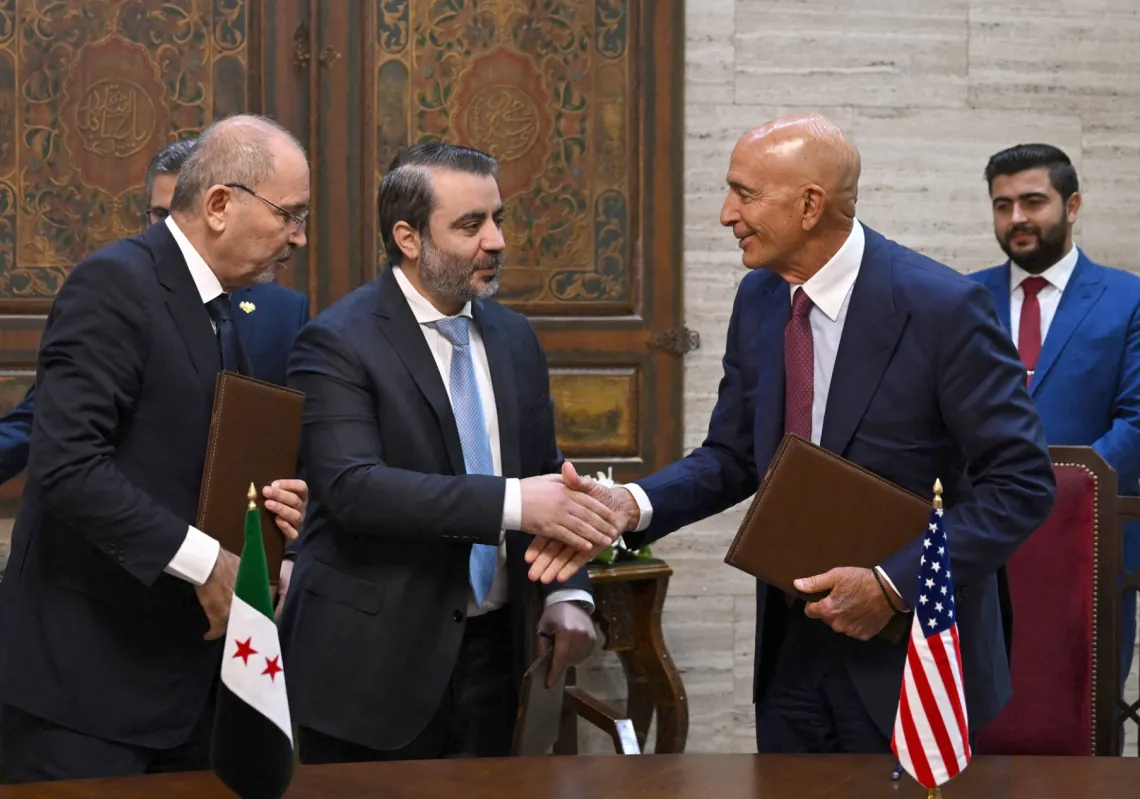 Jordanian Foreign Minister Ayman Safadi (left) watches as Syrian Foreign Minister Asaad al-Shaibani (center) greets US Special Envoy to Syria Tom Barrack after signing an agreement in Damascus on September 16, 2025.