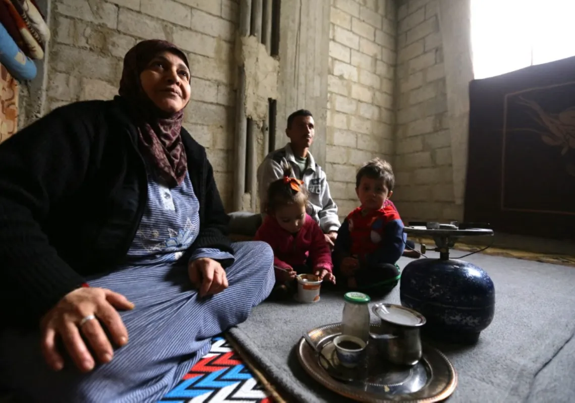 Umm Walid sits near her grandchildren in a room of an unfinished building where she lives with her five children and their families in the Daf al-Sakhr neighbourhood of Jaramana on the outskirts of the Syrian capital Damascus.