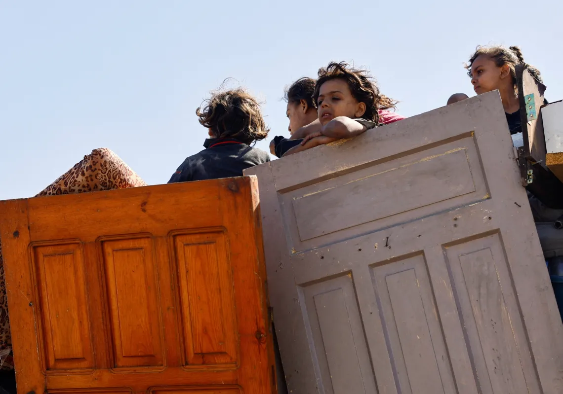 أطفال فلسطينيون يفرون من العملية العسكرية الإسرائيلية من شمال قطاع غزة على متن سيارة تقل أغراضا منزلية، بما في ذلك أبواب خشبية، متجهة جنوبا، في 21 سبتمبر
