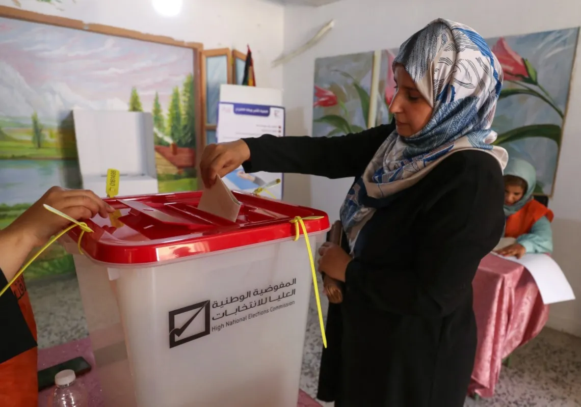 A Libyan voter casts her ballot for municipal elections at a polling station in Tripoli on August 16, 2025. 