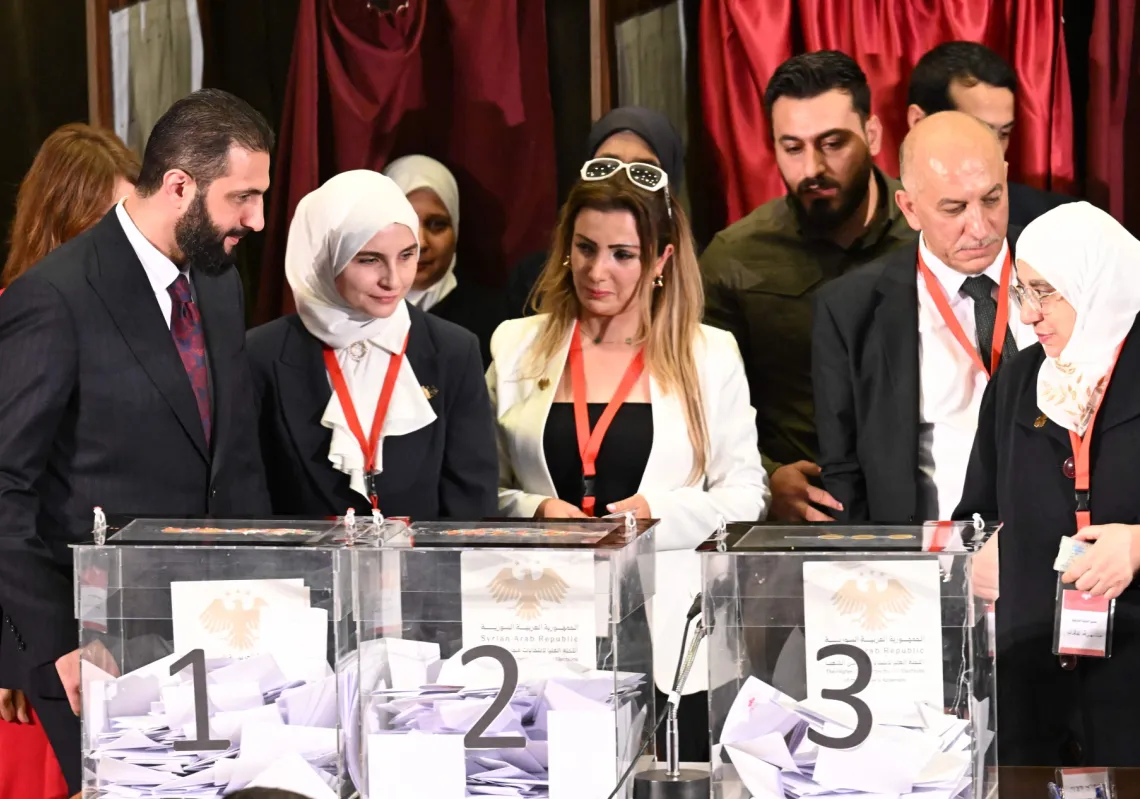 Syrian President Ahmed al-Sharaa (L) visits the polling station where members of Syrian local committees have been casting their votes to select members of an interim parliament, in Damascus on October 5, 2025.