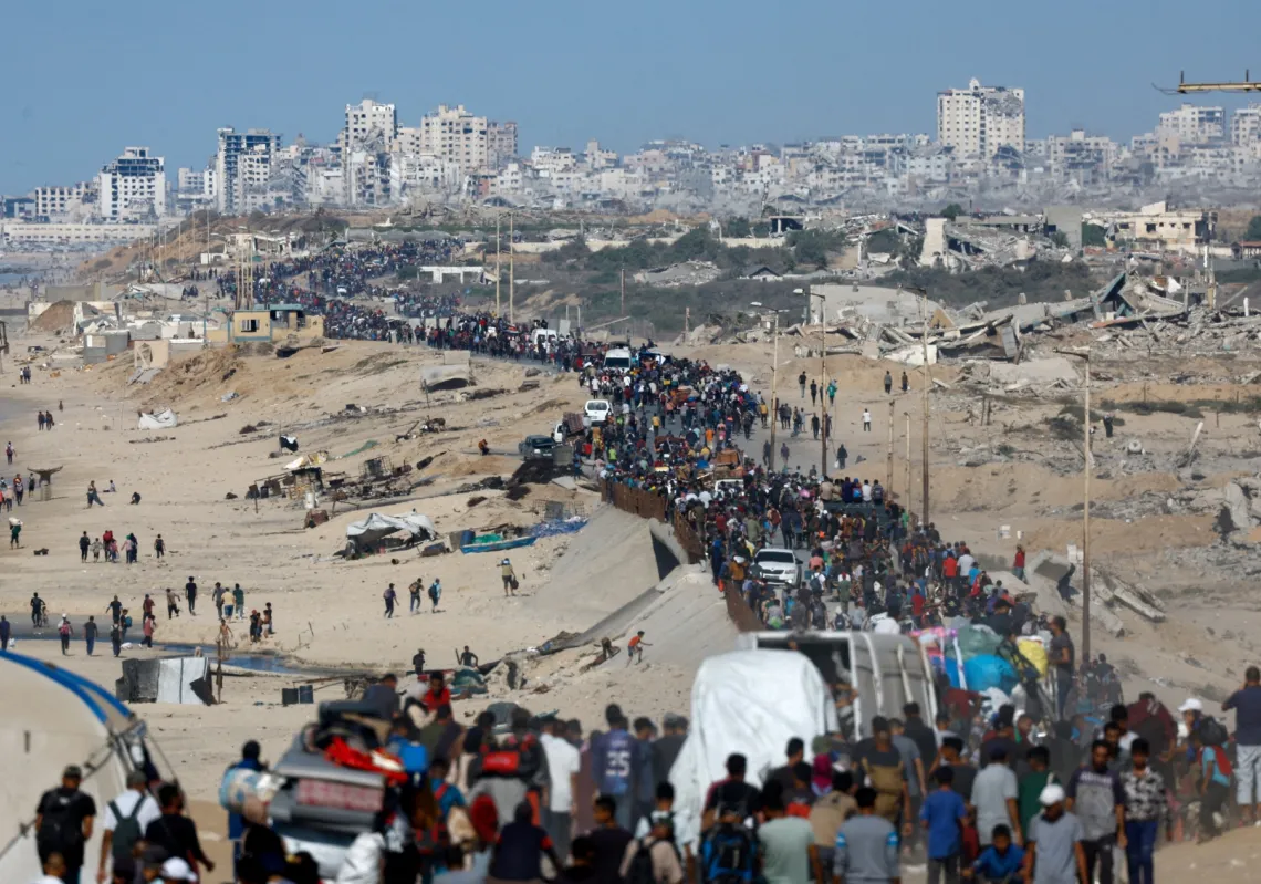 Palestinians, who were displaced to the southern part of Gaza at Israel&#039;s order during the war, make their way along a road as they return to the north after a ceasefire went into effect on October 10, 2025.