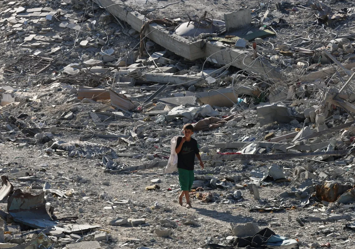 طفل فلسطيني يمشي بين الأنقاض بعد انسحاب القوات الإسرائيلية من خان يونس، جنوب قطاع غزة 11 أكتوبر 2025