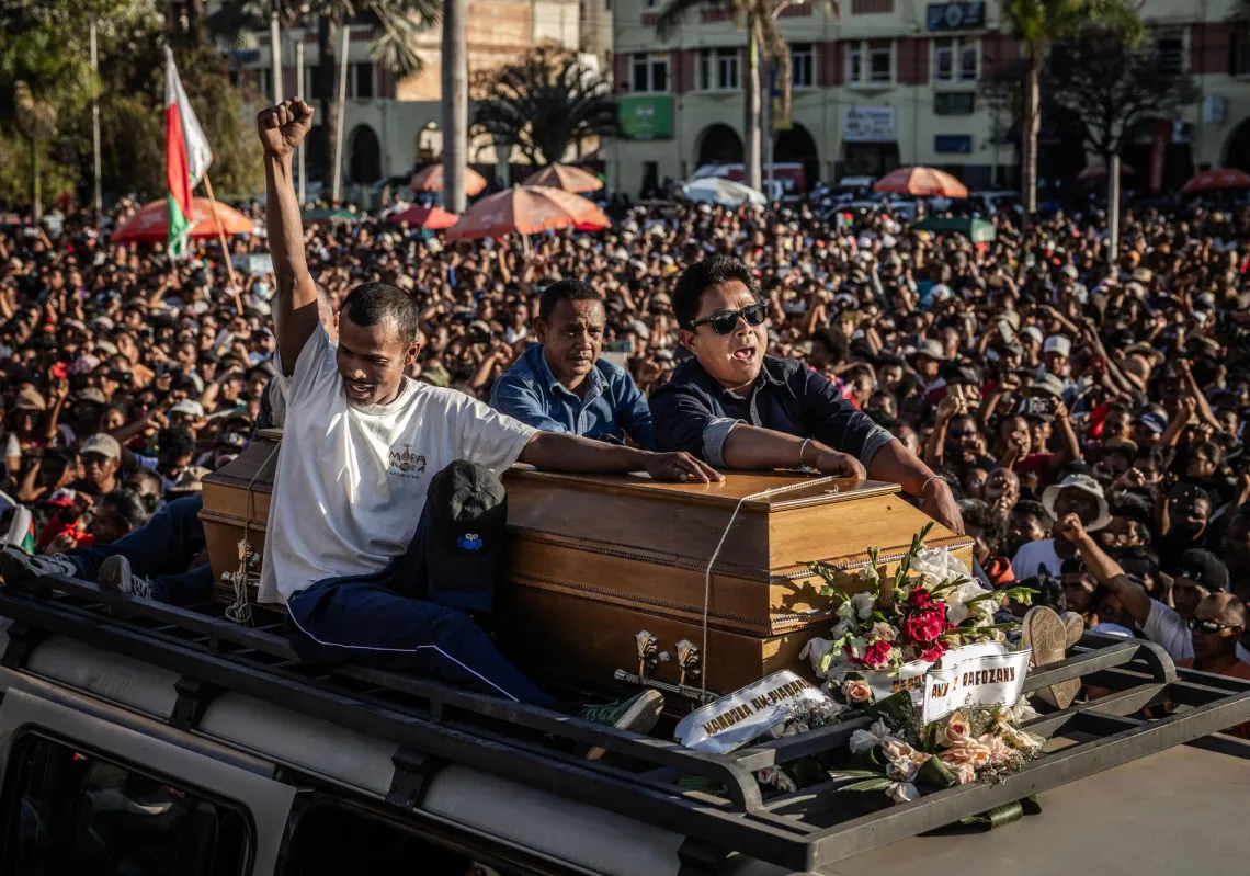 Family members of a protester killed during clashes carry the casket atop a van as protesters gather around during a civil society rally demanding the resignation of President Andry Rajoelina in Antananarivo, on October 13, 2025.