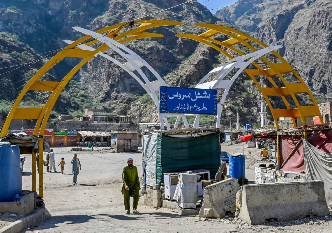 A man walks across a bus stand at the Pakistan-Afghanistan border town of Torkham on October 13, 2025, amid cross-border clashes between the two countries. 