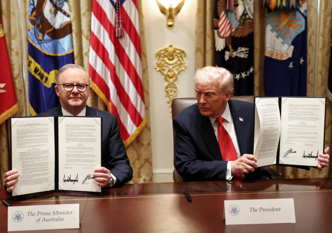 US President Donald Trump and Australia's Prime Minister Anthony Albanese hold a signed agreement on rare earths and critical minerals during a meeting in the Cabinet Room at the White House in Washington, DC, on October 20, 2025. 