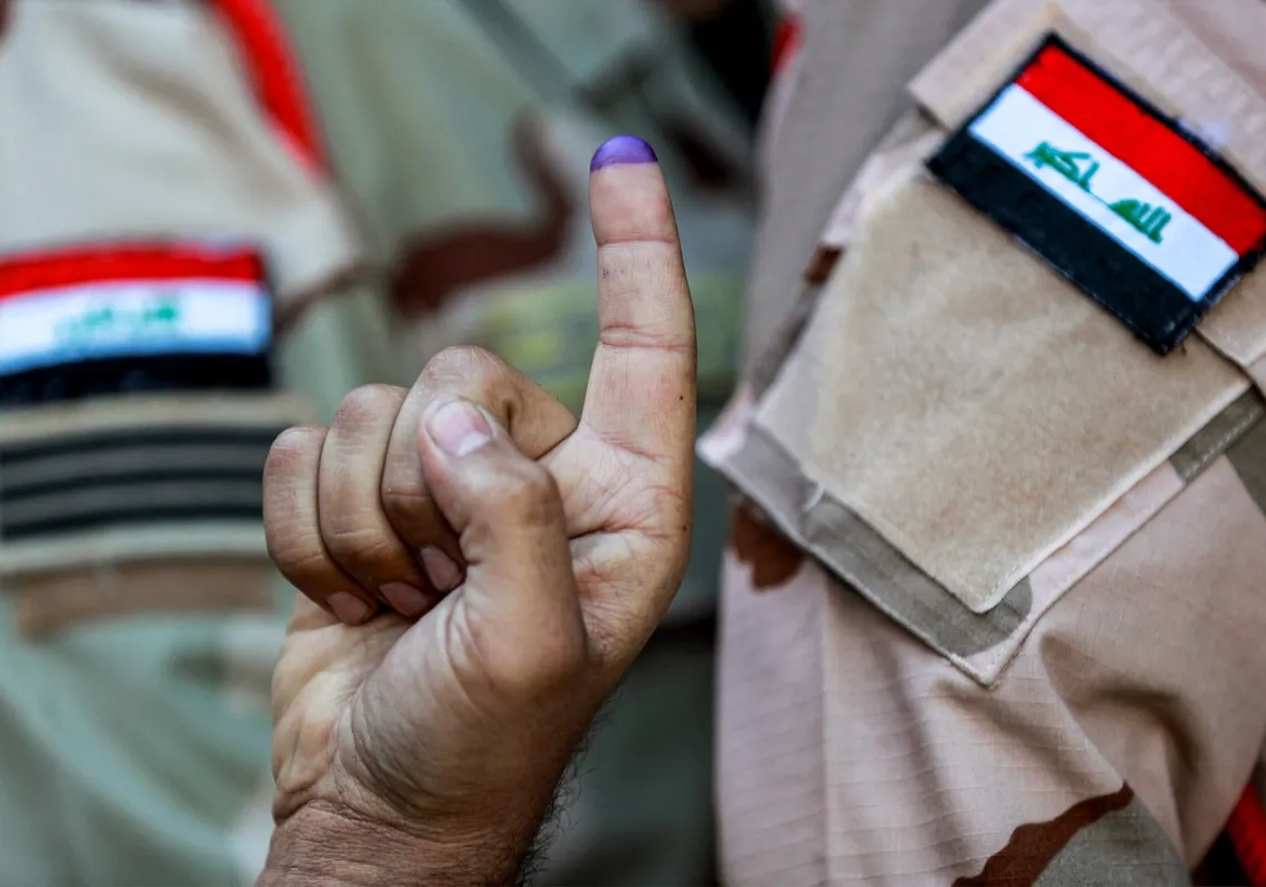 جندي عراقي يرفع إصبعه الملطخ بالحبر بعد التصويت في الجولة الأولى لانتخابات المجالس البلدية العراقية لعام 2023، في الكاظمية شمال بغداد