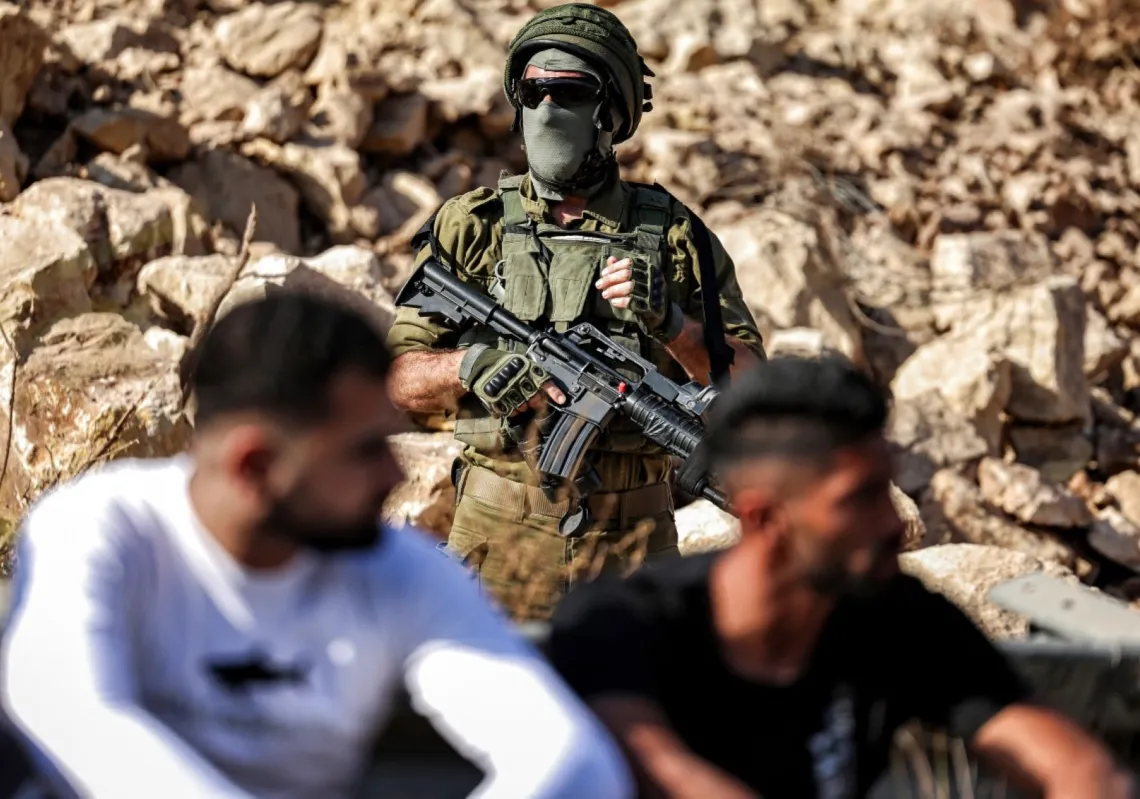 جندي إسرائيلي يقف حارسًا خلال تظاهرة للفلسطينيين في موقع طريق جديد قيد الإنشاء لاستخدام المستوطنين الإسرائيليين بالقرب من قرية بيت عور الفلسطينية، غرب رام الله في الضفة الغربية المحتلة، في 29 سبتمبر 2025