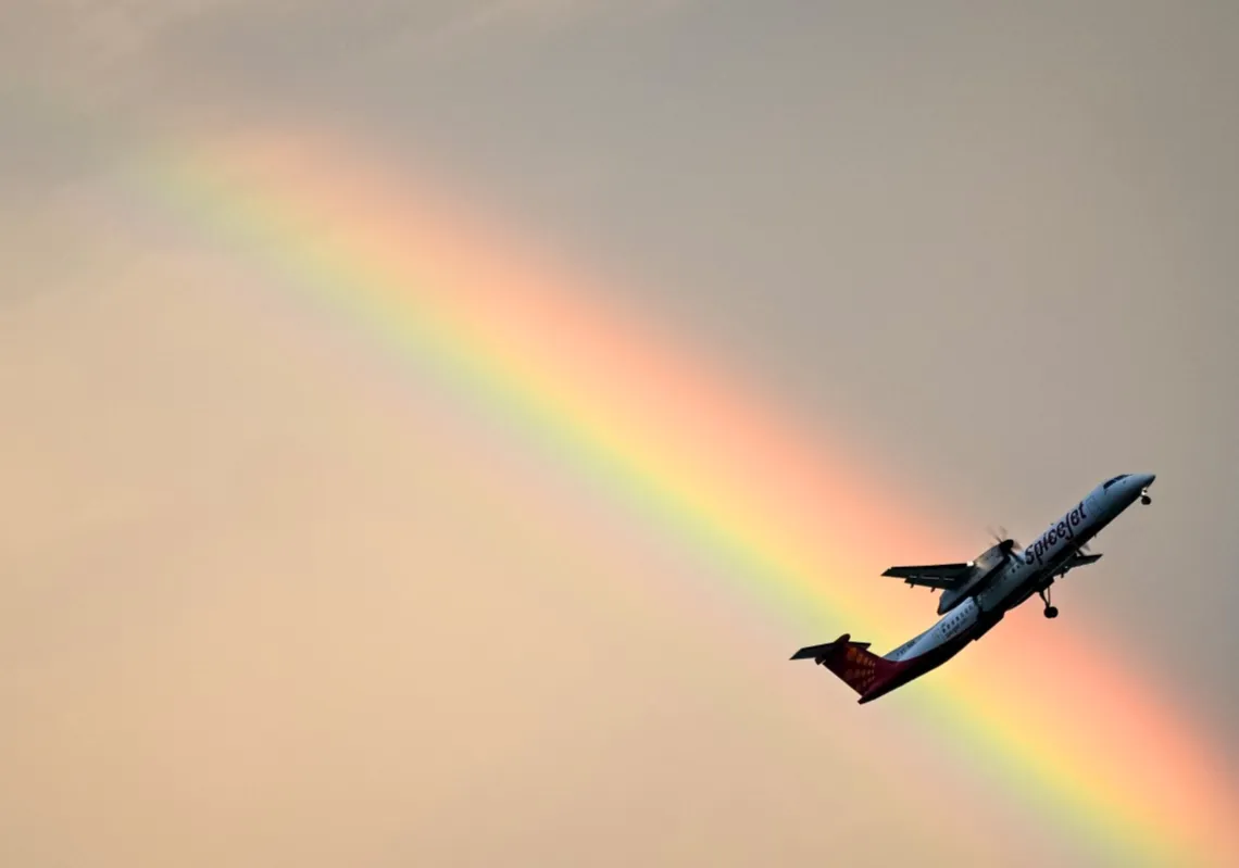 A SpiceJet aircraft flies past a rainbow during the dusk in Chennai, India, on September 29, 2025. 