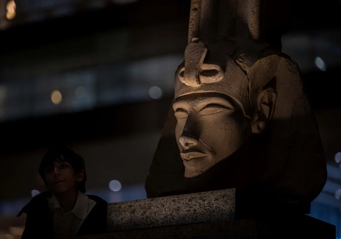 A visitor walks near a bust of the ancient Egyptian King Akhenaten while touring the Grand Egyptian Museum, in Giza on the southwestern outskirts of the capital Cairo on 7 February 2025.