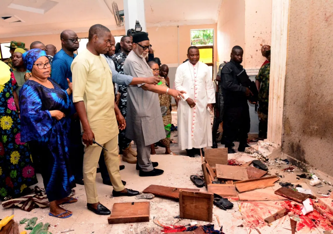 Ondo State governor Rotimi Akeredolu (3rd L) points to blood the stained floor after an attack by gunmen at St. Francis Catholic Church in Owo town, southwest Nigeria on 5 June 2022.