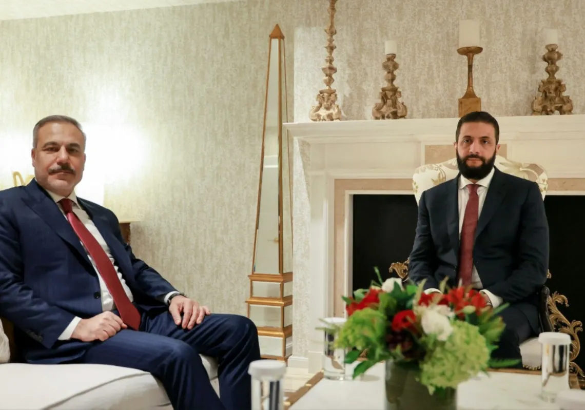 Syria's President Ahmed al-Sharaa (R) meets with the Turkish Foreign Minister Hakan Fidan, on the sidelines of their official visit to Washington DC on 11 November 2025.
