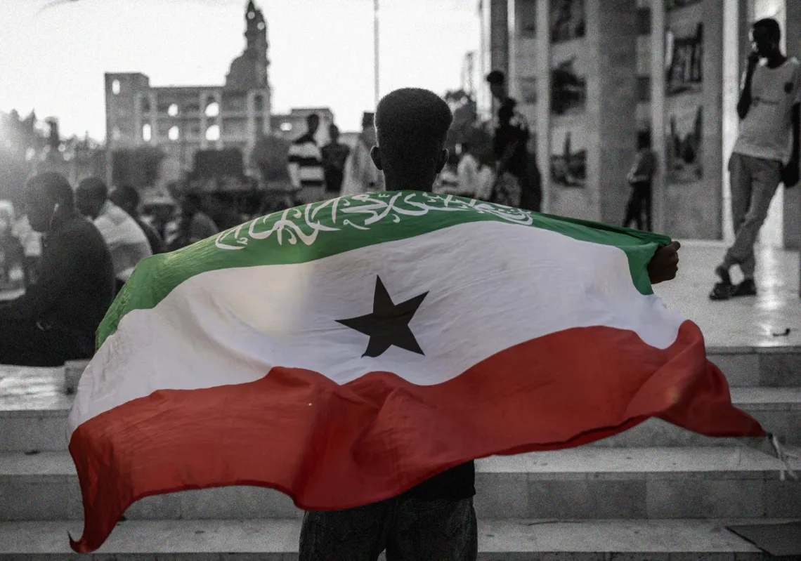 رجل يحمل علم أرض الصومال أمام نصب هرجيسا التذكاري للحرب هناك، 7 نوفمبر 2024.