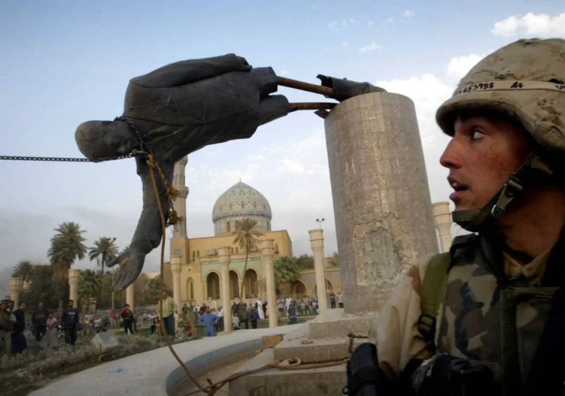 US Marine Corp Assaultman Kirk Dalrymple watches as a statue of Iraq's President Saddam Hussein falls in central Baghdad's Firdaus Square, in this file photo from 9 April 2003.