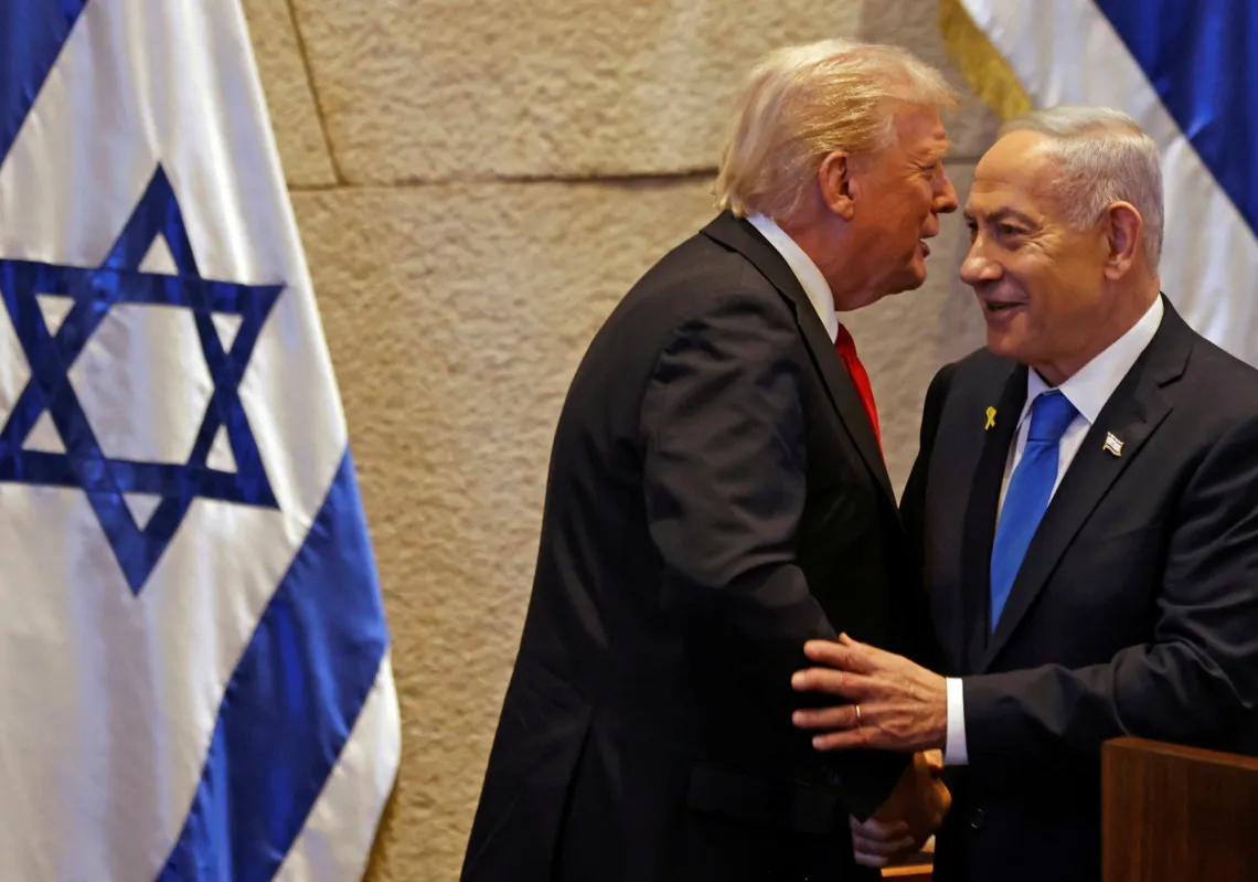 
الرئيس الأميركي دونالد ترمب (يسار) يتحدث مع رئيس الوزراء الإسرائيلي بنيامين نتنياهو في البرلمان الإسرائيلي، الكنيست، في القدس في 13 أكتوبر 2025