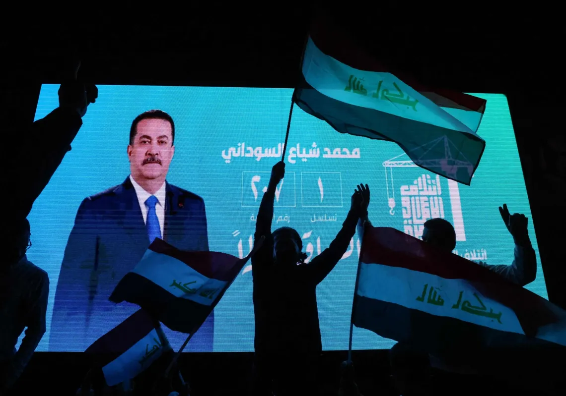 أنصار السوداني الحالي يلوحون بالأعلام الوطنية أثناء احتفالهم بعد الإعلان عن نتائج الانتخابات الأولية في بغداد في 12 نوفمبر 2025.