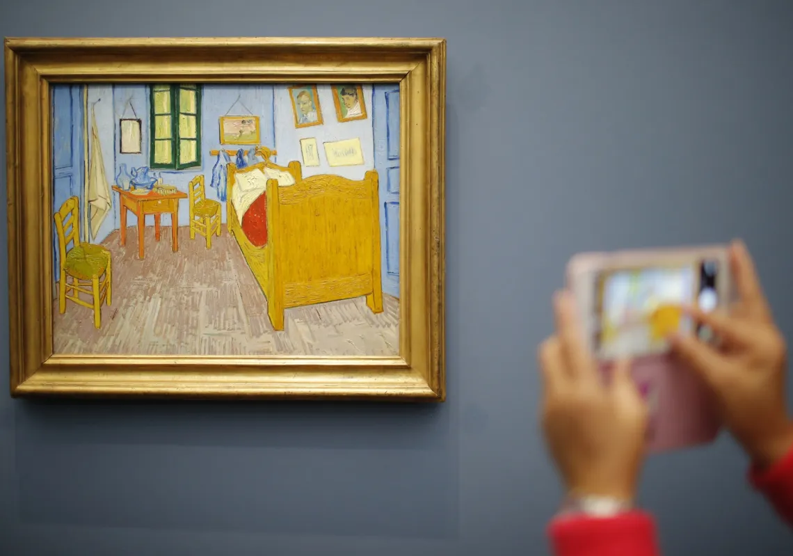 A visitor takes a picture of the painting La Chambre de Van Gogh a Arles, 1888 (Van Gogh's Bedroom in Arles) at the Musee d'Orsay in Paris, France.