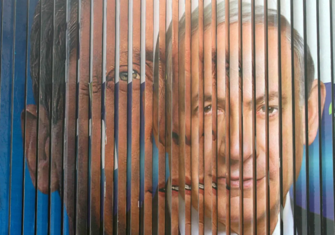A giant campaign billboard rotates showing Likud candidate Benjamin Netanyahu (R) and Labour Party leader Isaac Herzog (L) in March 2015. Today, Netanyahu is asking Herzog to grant him a presidential pardon.