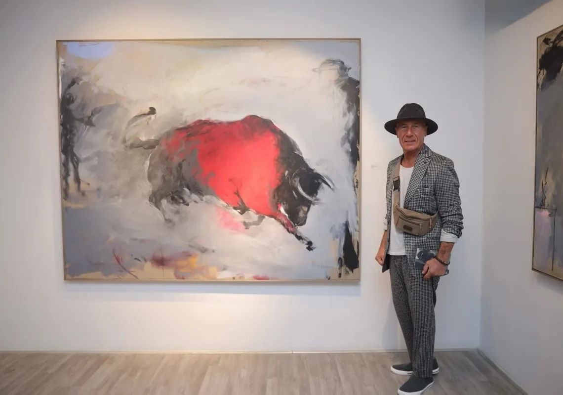 بهرام حاجو أمام أحد أعماله