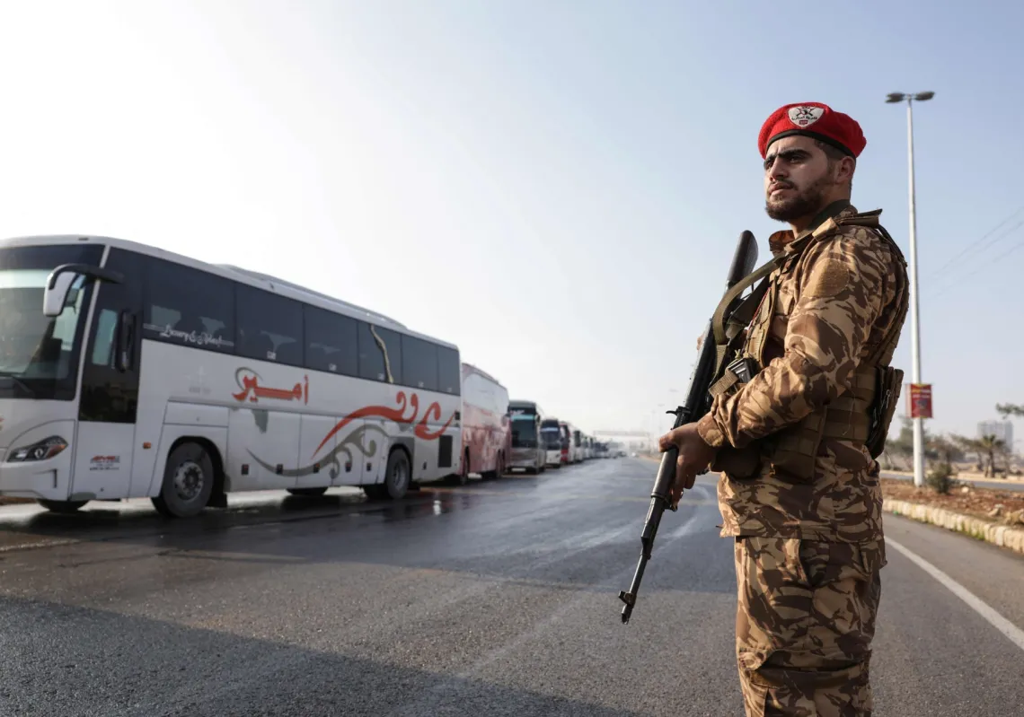 Buses wait to enter the Sheikh Maqsoud neighbourhood to evacuate US-backed Kurdish-led Syrian Democratic Forces (SDF) force fighters from two districts of the city of Aleppo, northern Syria, on 9 January 2026.